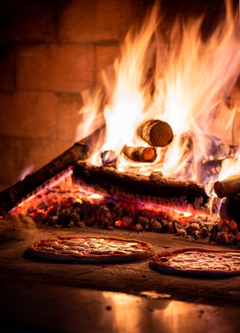Traditional wood-fired pizza fresh from the oven with a charred, artisan crust